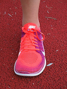person wearing pink and orange Nike running shoe thumbnail