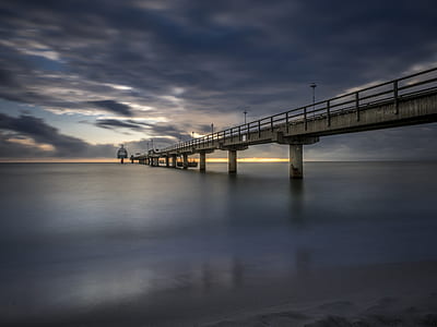 gray concrete bridge under white cloudy sky during daytime thumbnail