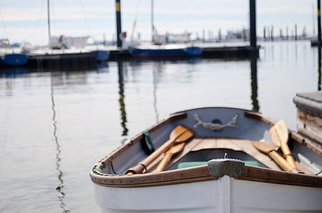 white and brown wooden boat with oars near dock thumbnail