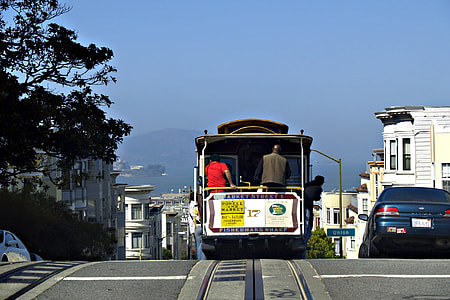 man rides on white and brown tram thumbnail