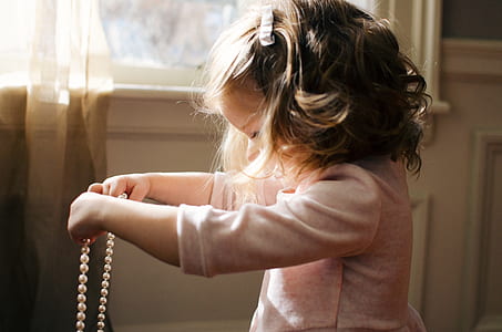 girl holding beaded necklace thumbnail