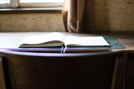 opened book on table near window thumbnail