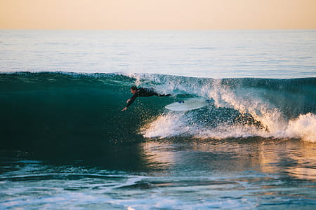man surfing during daytime thumbnail