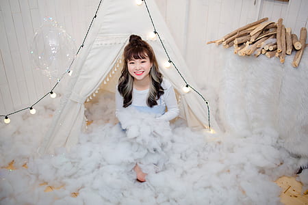 woman sitting near white wall thumbnail