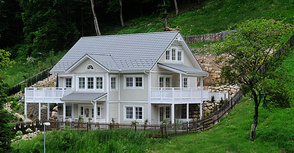 white and gray 3-storey house surrounded with grass thumbnail