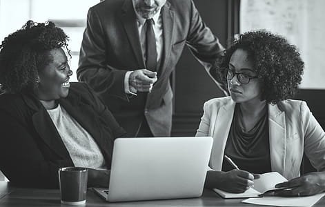 Monochrome Photography of People Near Laptop thumbnail