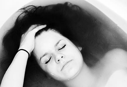 grayscale photography of woman taking bath thumbnail