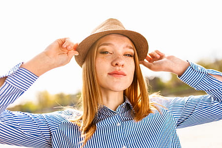 Woman Wearing Brown Hat and Blue Striped Dress Shirt thumbnail