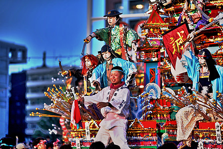 man performing on front of figurines on red house model thumbnail