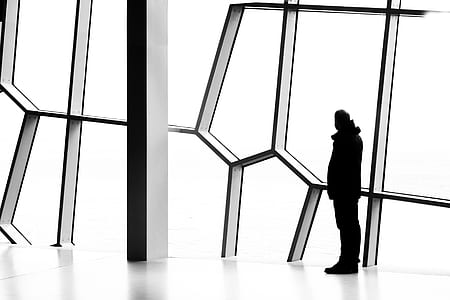 silhouette photography of person standing while watching on window thumbnail