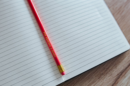 Notebooks with colourful pencils on a wooden desk thumbnail