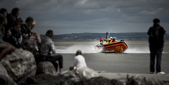 selective focus color photo of speedboat on body of water heading seashore thumbnail