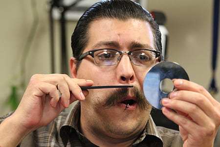man trimming his beard at daytime thumbnail