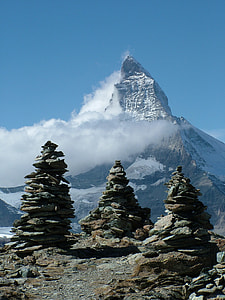 three pile of rocks near mountain thumbnail