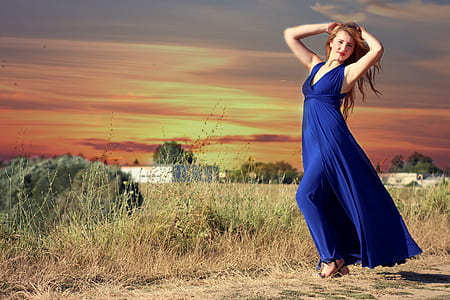woman wearing blue jumpsuit standing near grass thumbnail