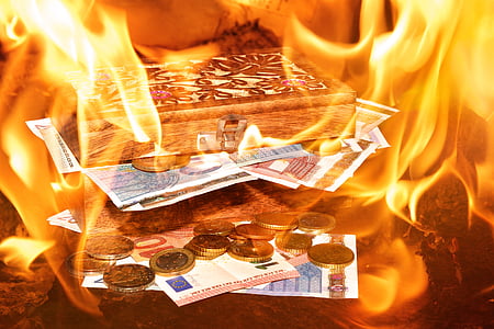 banknote on brown wooden box while on flames thumbnail