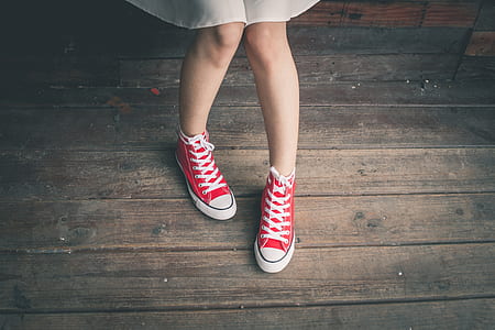 woman showing pair of red high-top sneakers thumbnail