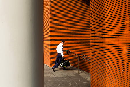 person walking towards stair carrying bag thumbnail