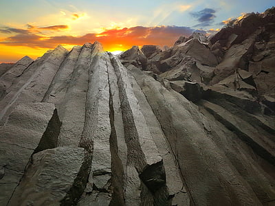 low angle photography of mountain against sunset thumbnail