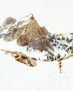woman running towards snow covered mountainm thumbnail