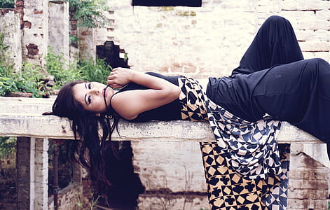 woman wearing black and white dress lying on white concrete surface thumbnail
