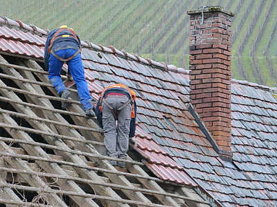 two person putting roof tiles on roof at daytime thumbnail