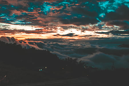 landscape photography of mountain and trees under clouds thumbnail