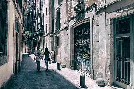 A couple of people walk through the streets of the Gothic Quarter in Barcelona, Spain thumbnail