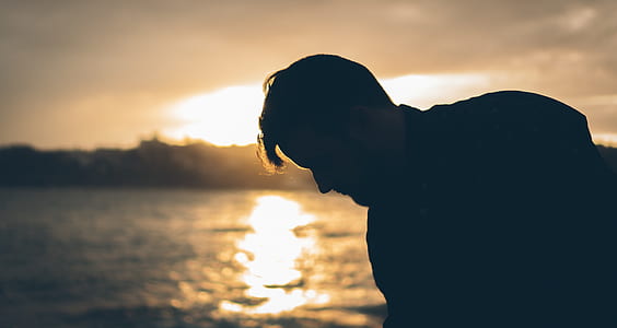 silhouette photo of man near body of water thumbnail