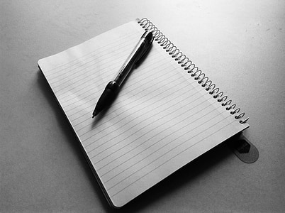 black retractable pen on spiral notebook thumbnail
