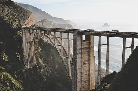 brown concrete bridge across mountains during daytime thumbnail