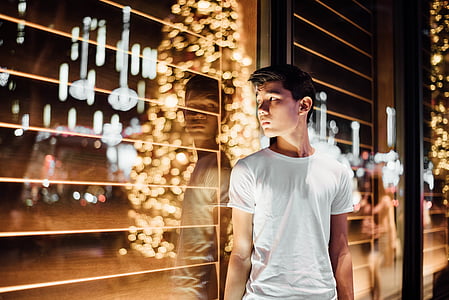 man standing against glass wall thumbnail