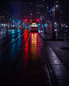 white and black tram beside waiting shed during nigh time thumbnail