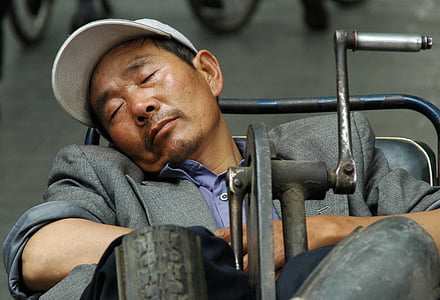 selective focus photo of sleeping man on blue vehicle thumbnail