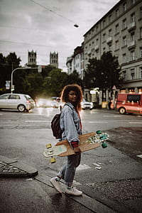 woman holding longboard standing nearroad thumbnail