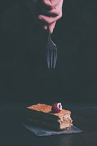 person holding fork pointing at slice of cake with strawberry topping thumbnail