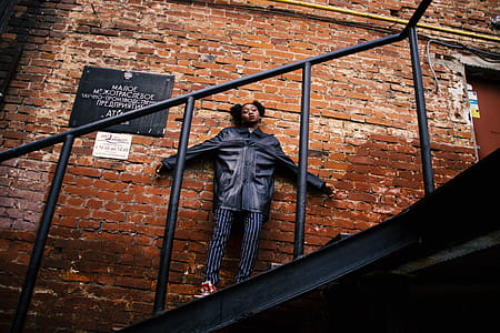 Woman in Black Jacket Standing on the Stairs thumbnail