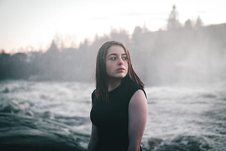 woman in black sleeveless top beside body of water thumbnail