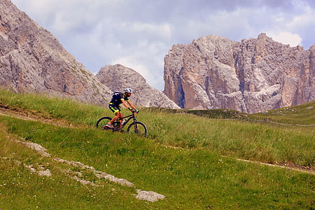 man riding bicycle along green grass field thumbnail