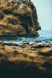 shallow focus photography of rock formation on body of water thumbnail