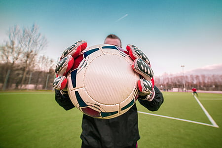 soccer player holding white and black ball thumbnail