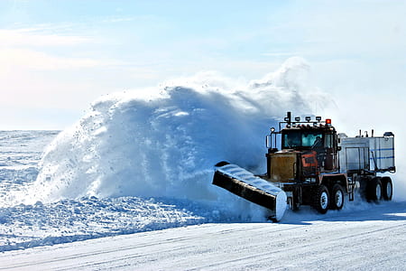 black freight truck with snow plow blade in snow covered ground during daytime thumbnail