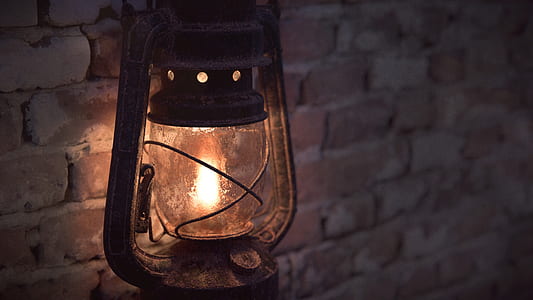 gray kerosene lantern beside brick wall thumbnail