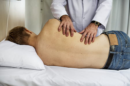 Person Massaging Man While Lying on Bed thumbnail