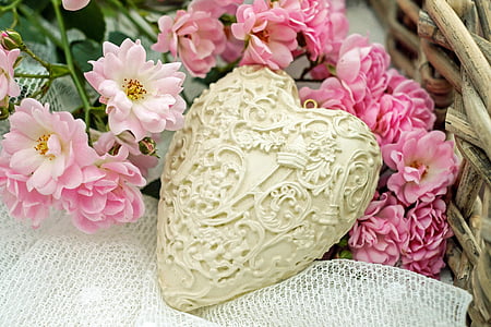 heart-shaped white container on top of white surface and pink petaled flowers thumbnail