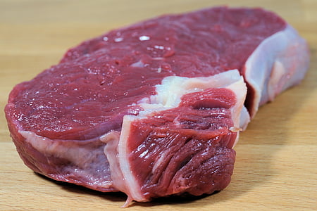 raw meat on top of beige chopping board thumbnail