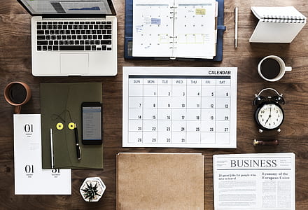 MacBook Pr, white calendar and brown folding on brown wooden desk thumbnail
