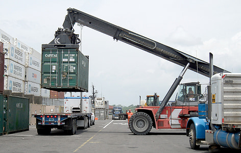 red and black heavy equipment carrying green intermodal container thumbnail