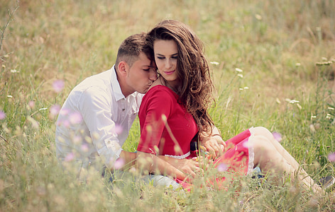 man and woman sitting on grass field during daytime thumbnail