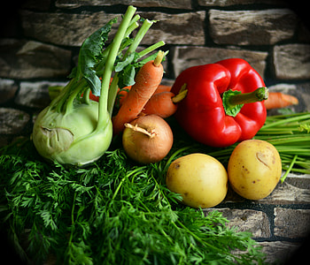 red bell pepper beside orange carrots and potatoes vegetables in close up photo thumbnail
